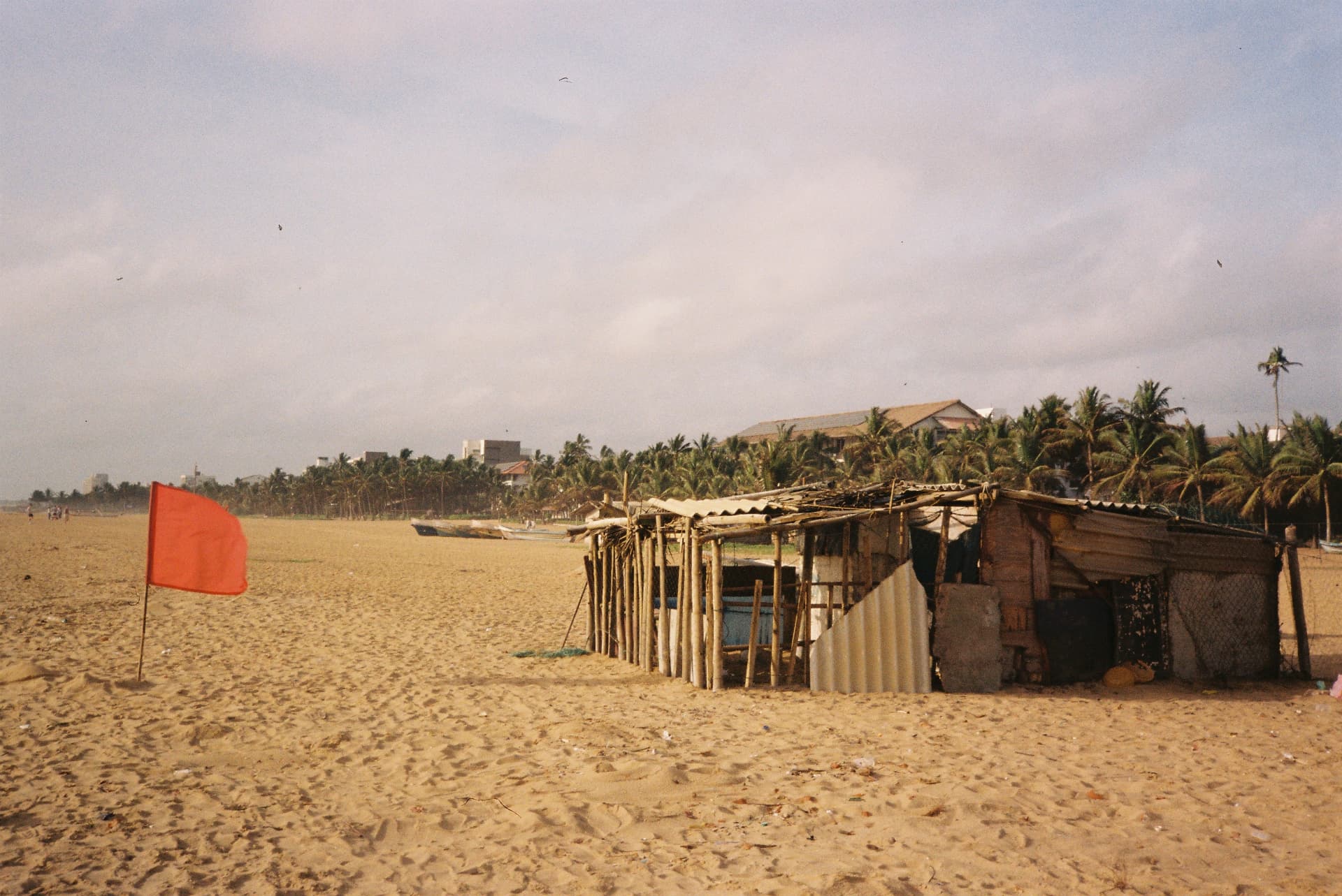 Red flag and bamboo fishing hut on a Sri Lankan beach